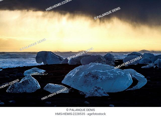 Iceland, South coast, Jökulsa beach, icebergs rejected by the sea on the black pebble beach, sunrise, Jökulsa beach in the storm