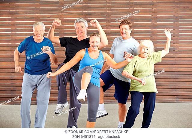 Lächelnde Gruppe Senioren turnt beim Piloxing Kurs im Fitnesscenter
