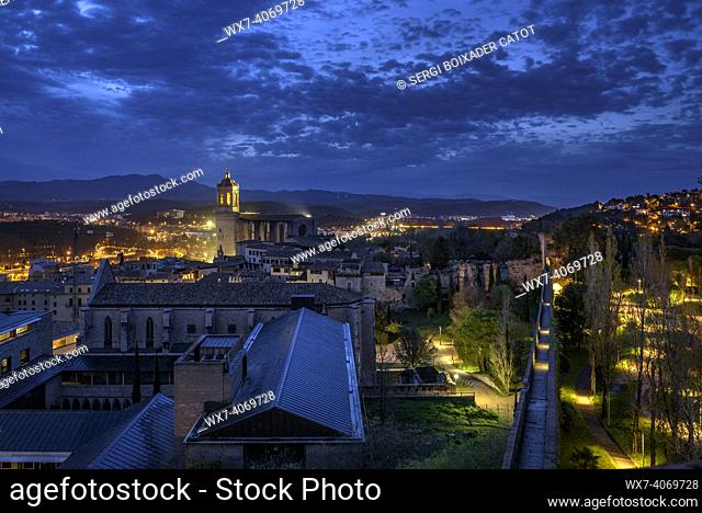 The city of Girona seen from the Sant Domènec tower in the wall of Girona, at twilight and night (Girona, Catalonia, Spain)