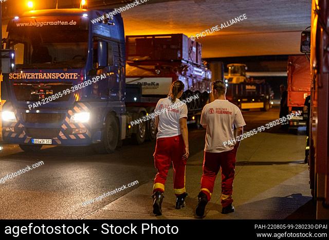 05 August 2022, Berlin: During the night, firefighting tanks reach the assembly point for emergency vehicles at the Hüttenweg highway bridge
