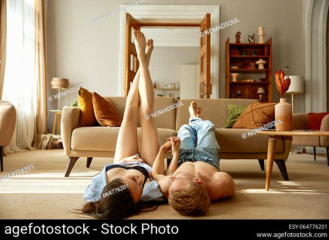 Joyful loving heterosexual couple having tender romantic moment together at home living room