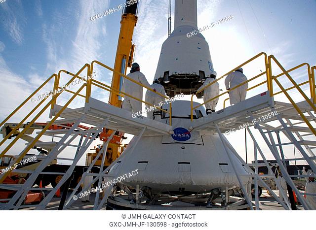 The launch abort system for the Pad Abort-1 (PA-1) flight test is lifted onto the boilerplate crew module at the launch pad in preparation for the test at the U