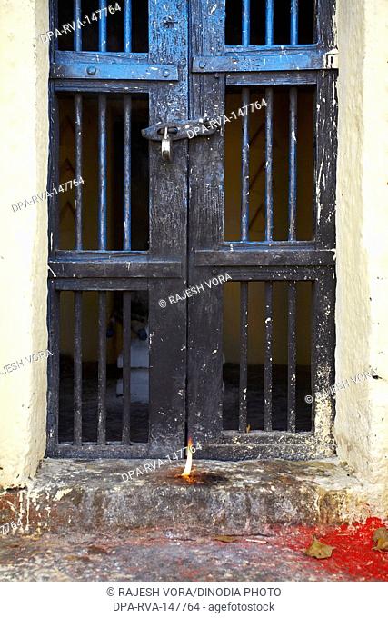 A lamp lit by a devotee in front of a door of a temple ; Andhra Pradesh ; India
