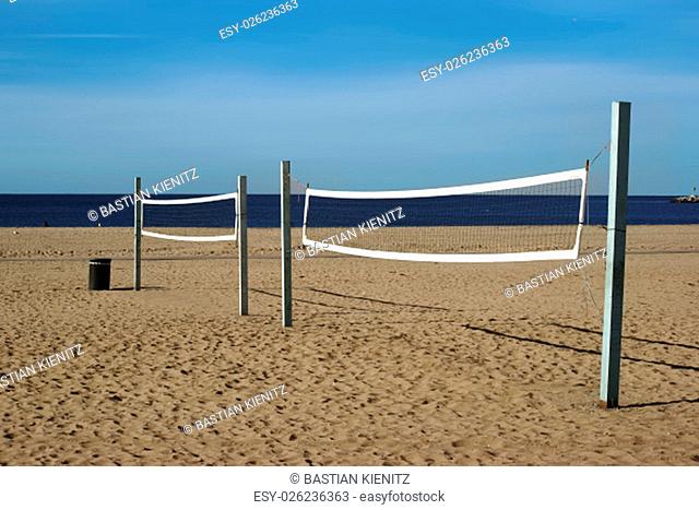 a beach volleyball court with a volleyball net on the beach in long beach, overlooking the ocean