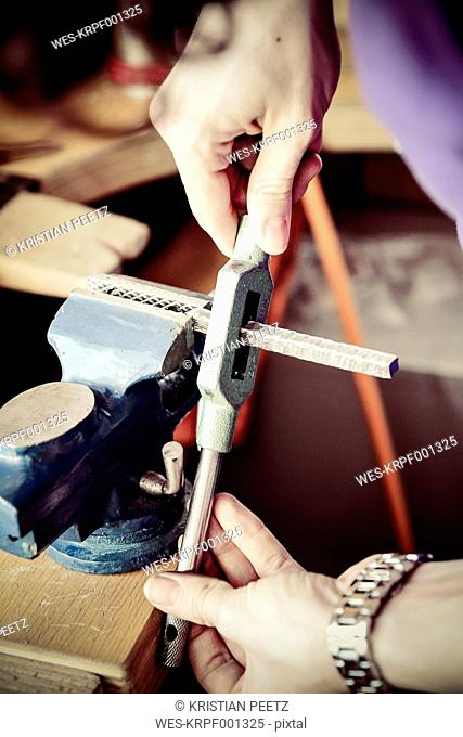 Goldsmith working on wedding rings in Mokume Gane style, preparing bench vice