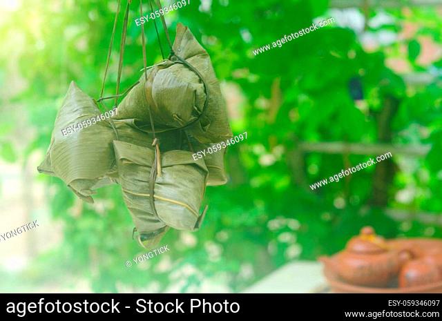 Chinese tradition food - Chinese Steamed Rice Dumpling with bokeh background outdoor.Zongzi or traditional chinese sticky rice dumpling usually taken during...