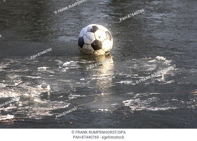 A soccer ball embedded in a thin layer of ice which has formed on the Nidda, a small river in the north of Frankfurt am Main, Germany, 22 January 2017