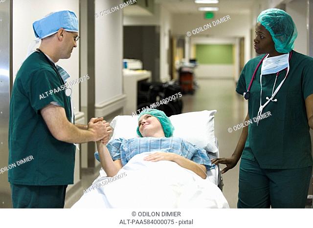 Doctor reassuring patient lying on hospital gurney