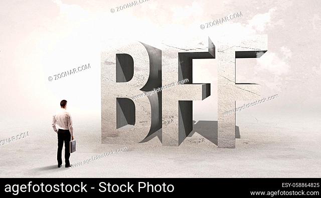 Rear view of a businessman standing in front of BFF abbreviation, attention making concept