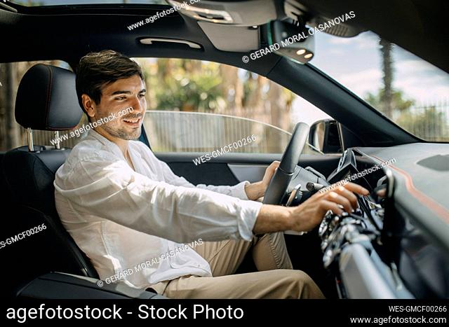 Young man using control panel of electric car