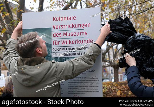 16 November 2022, Berlin: People remove a protective film before the start of the dedication of the memorial stele ""Colonial Involvements of the Museum of...