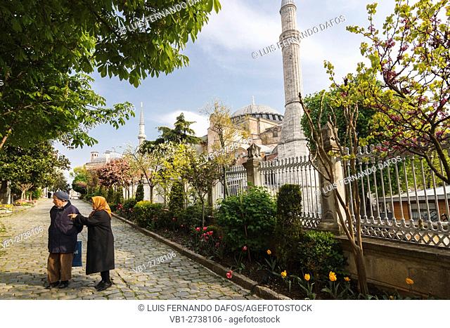 Old Turkish couple by lateral view of Hagia Sophia. Istanbul, Turkey