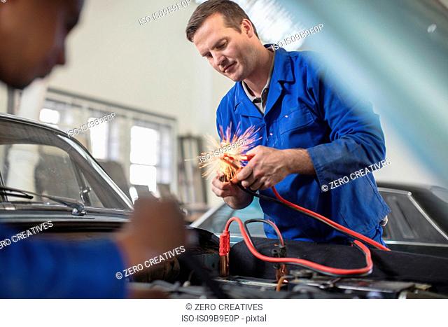 Car mechanics testing car engine in repair garage
