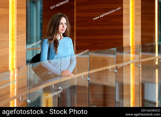 Beautiful woman with backpack on balcony looking through window before departure