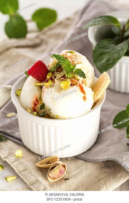 Vanilla ice cream with raspberries, mint, nuts and jam