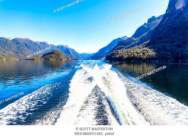 Water wake in Lake Manapouri against clear blue sky at Fiordland National Park, Te Anau, South Island, New Zealand