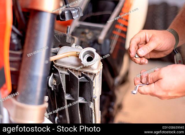 Motorbike mechanic, replacing the cooling radiator. Replacement or radiator maintenance