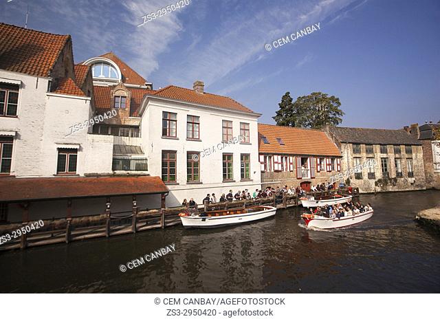 Tourists on the boat during a trip at the canal in the city center, Bruges, West Flanders, Belgium, Europe