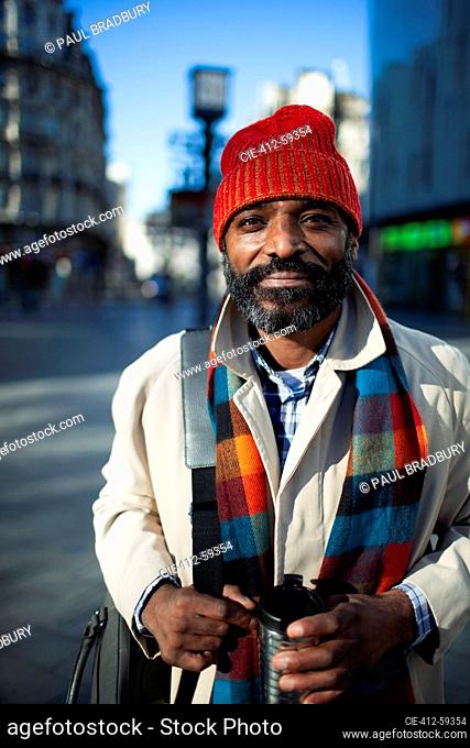 Portrait handsome businessman in stocking cap on urban street