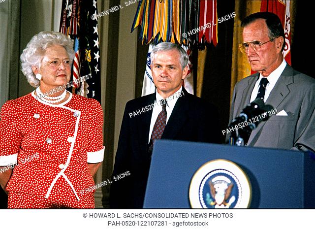 United States President George H.W. Bush and first lady Barbara Bush present the Presidential Citizens Medal to Deputy National Security Advisor Robert Gates...