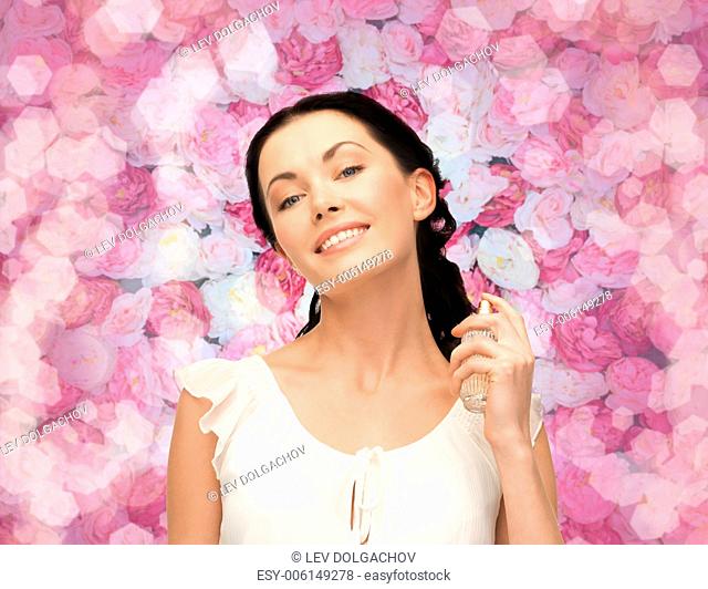 cosmetics and beauty concept - beautiful woman spraying pefrume on her neck