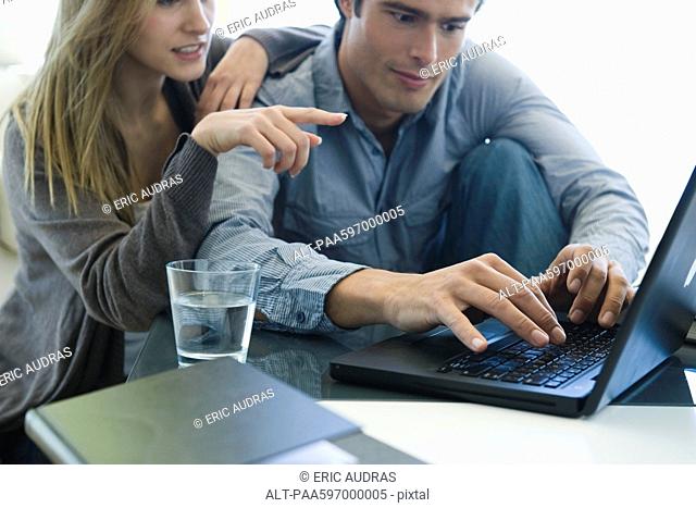 Couple using laptop together