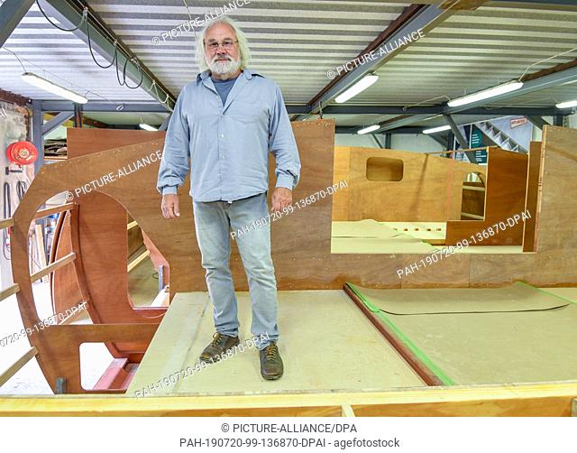 16 July 2019, Brandenburg, Kienitz-Nord: Frank Ladwig, President of the organization FYD-Adventure, stands in a hall on the shell of a catamaran