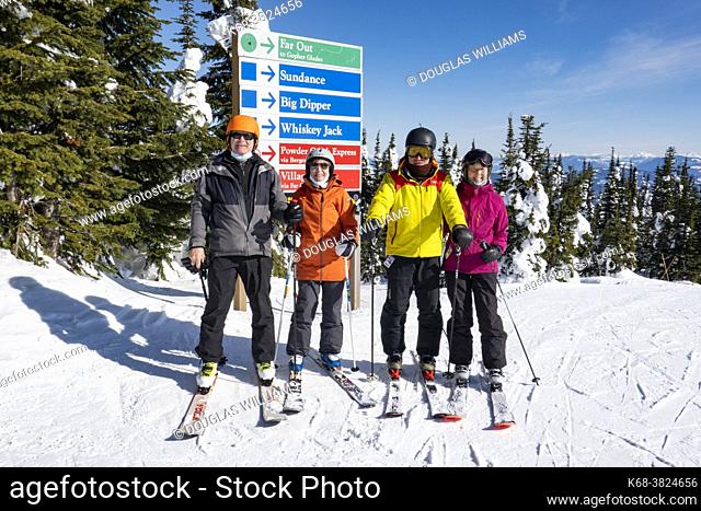 Two senior couples pose at the top of the mountain at Silver Star ski resort near Vernon, BC, Canada