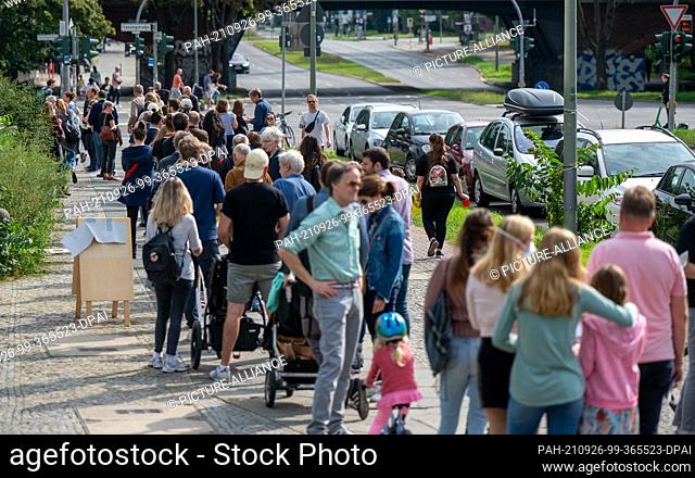 26 September 2021, Berlin: Numerous people stand in a long line in front of the polling stations in the Tiergarten Gymnasium on Altonaer Straße