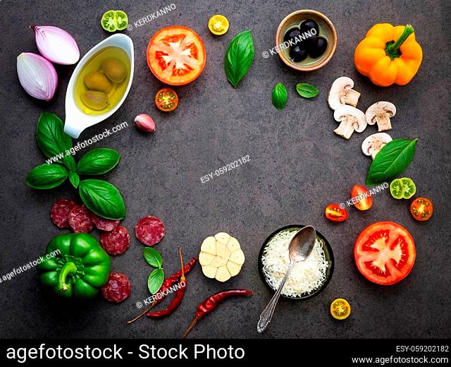 The ingredients for homemade pizza on dark stone background