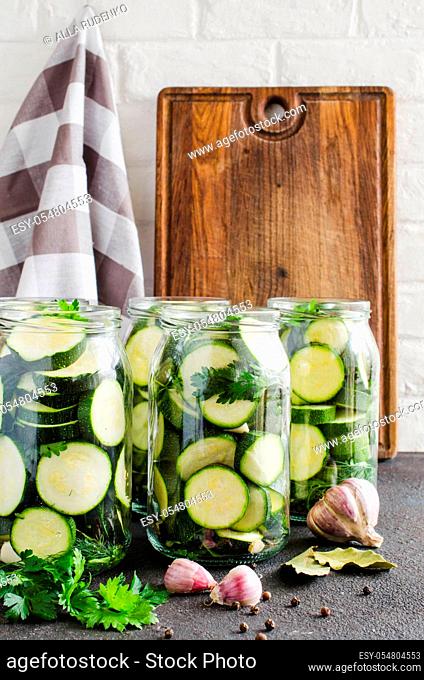 Conservation zucchini and fresh vegetables for the winter. Sliced zucchini with parsley and garlic, homemade vegetables preserves in glass jar
