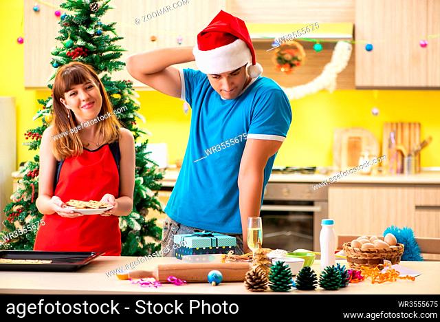 Young couple celebrating Christmas in kitchen
