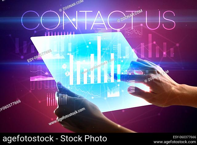 Hand holding futuristic tablet with CONTACT US inscription above, modern business concept