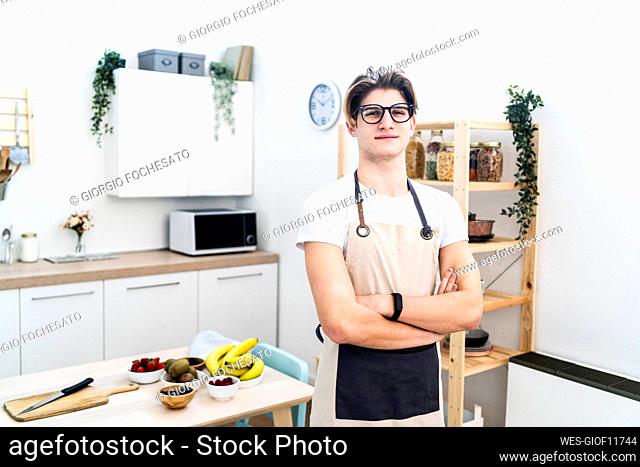 Man wearing apron standing in kitchen