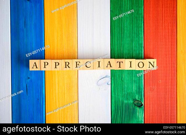 Top view of the word Appreciation spelled on wooden cubes with a background of colorful wooden planks