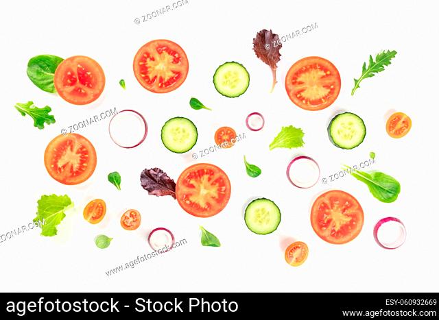 Fresh vegetable salad ingredients, shot from the top on a white background. A flat lay composition with tomato, cucumber, onion slices and mezclun leaves