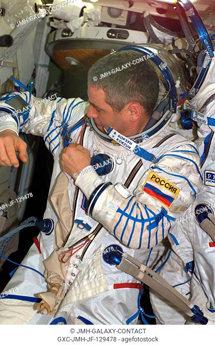Cosmonaut Valery G. Korzun, Expedition Five mission commander, dons a Russian Sokol suit in the functional cargo block (FGB)