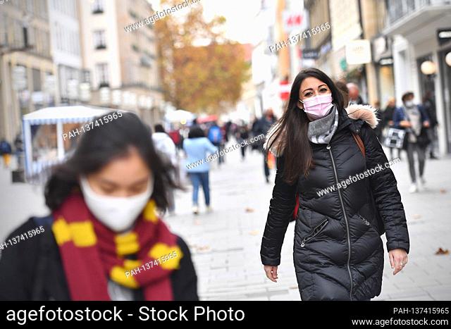 Mask compulsory in the pedestrian zones and public places in Munich on November 17th, 2020. Young woman with everyday mask walks through the Neuhauser Starsse