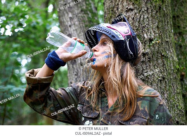 Paintball player drinking from bottle