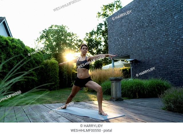 Woman practicing yoga in garden