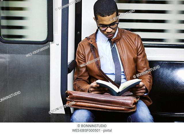 Businessman reading book on the subway train