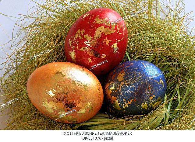 Coloured easter eggs with golden ornament in an easter basket
