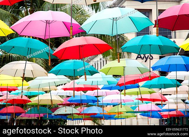Bunte Regenschirme über der Einkaufspassage Caudan Waterfront in Port Louis, Mauritius, Afrika. Colourful umbrellas hanging over the shopping mall Caudan...