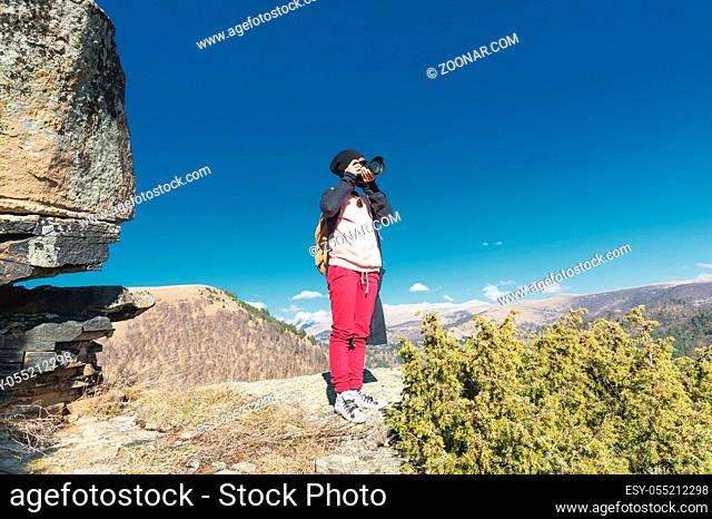 Nature Photographer taking pictures on his dslr camera outdoors during hiking trip on Caucasus. North Caucasus Russia