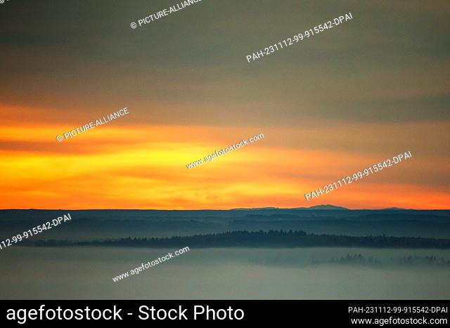 12 November 2023, Baden-Württemberg, Unlingen: View in the morning, shortly after sunrise over Upper Swabia. The sky only turns reddish for a short time before...