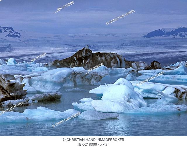 Icebergs in the glacial lake Joekulsarlon and in the background the Vatnajoekull glacier, Iceland