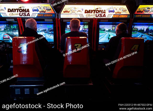PRODUCTION - 05 March 2022, Hessen, Seligenstadt: Visitors play the arcade game Daytona USA at the Pinball and Arcade Museum