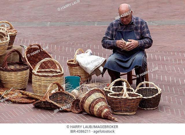Basket weaver, man on Piazza delle Erbe making baskets, San Gimignano, Province of Siena, Tuscany, Italy