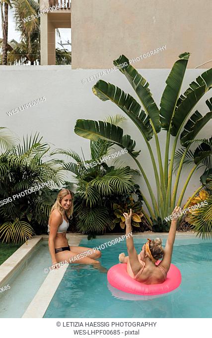 Two happy young women relaxing in swimming pool