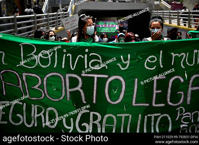29 October 2021, Bolivia, La Paz: Women wearing green mouth-to-nose coverings wave green scarves during a rally outside the bishops' conference as part of...